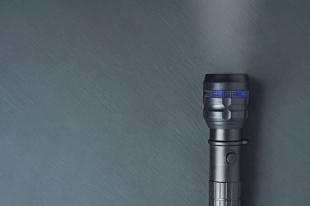 istock One black tactical flashlight lies on dark concrete table. Space for text. Top view 1188378027