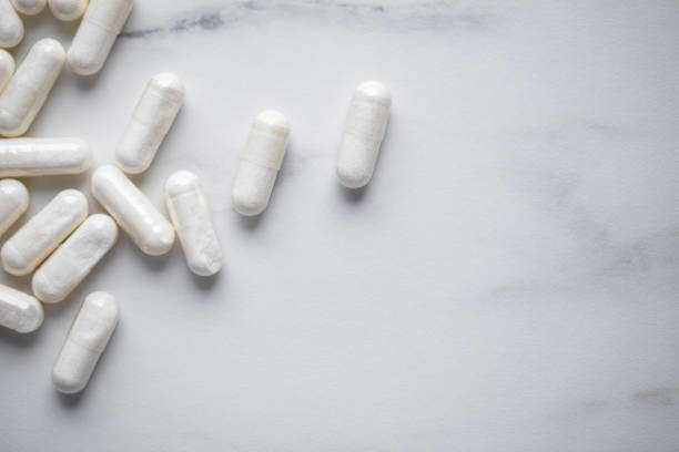 Heap Of Drugs with Glucosamine Sulphate capsules on marble background with copy space stock photo