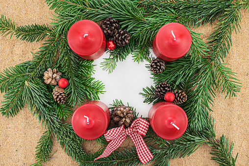 Overhead studio shot of an advent wreath.\n\nThis is number one image out of 5:\n#1 - All candles af unlit\n#2 - The first advent candle is lit\n#3 - Two advent candles are lit\n#4 - Three advent candles are lit\n#5 - All advent candles are lit
