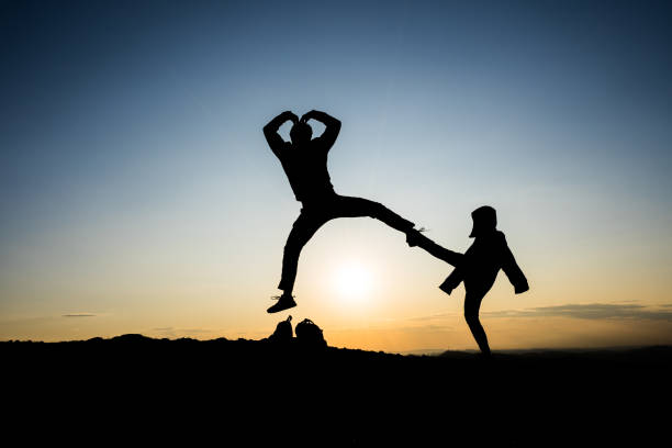 istock silhouette of two people jumping 1188381080
