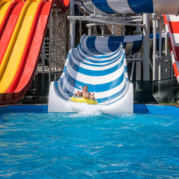 glückliche familie genießt wochenende im wasserpark - amusement park family water slide child stock-fotos und bilder