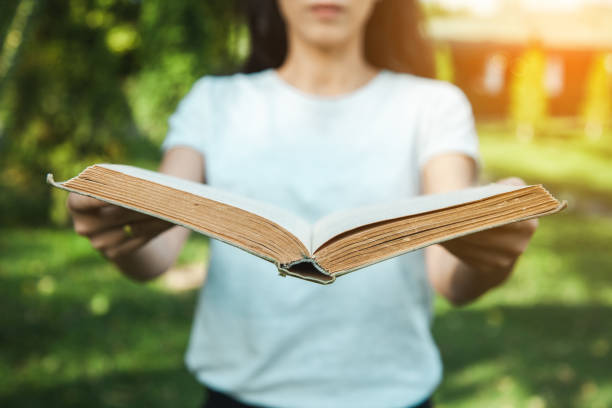 istock woman hand book in nature 1188381857