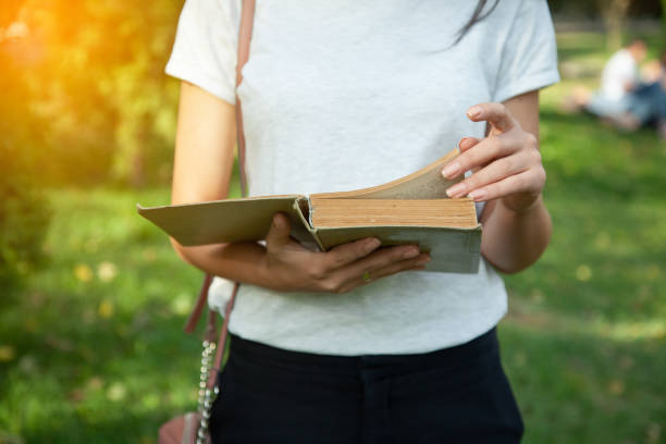 istock woman hand book in nature 1188381862