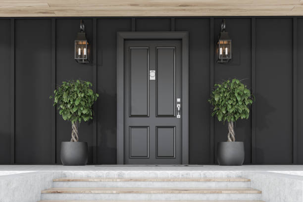 istock Black front door of black house with trees 1188382401