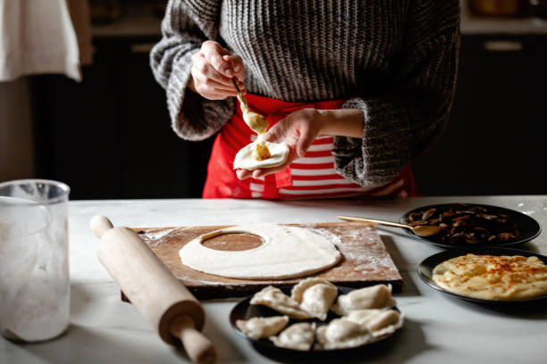 woman cooking  polish dumplings at kitchen woman cooking  polish dumplings at kitchen pierogi stock pictures, royalty-free photos & images