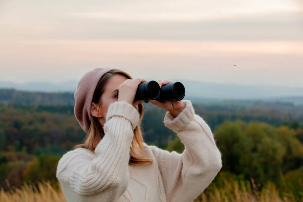 istock Style girl with binoculars at countryside with mountains on background 1188382903