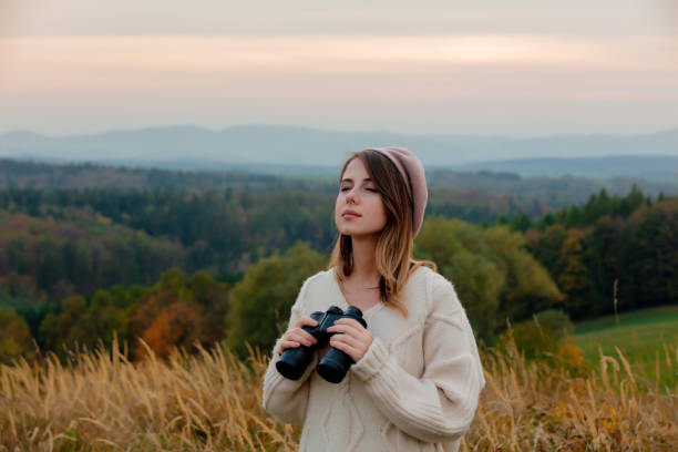 istock Style girl with binoculars at countryside with mountains on background 1188382904