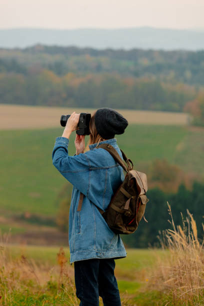 istock Style girl with camera and backpack at countryside with mountains on background 1188382906