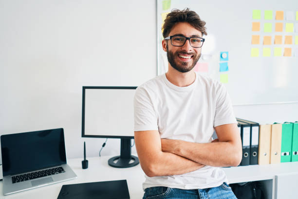istock Happy young man sitting on desk in startup office 1188383067