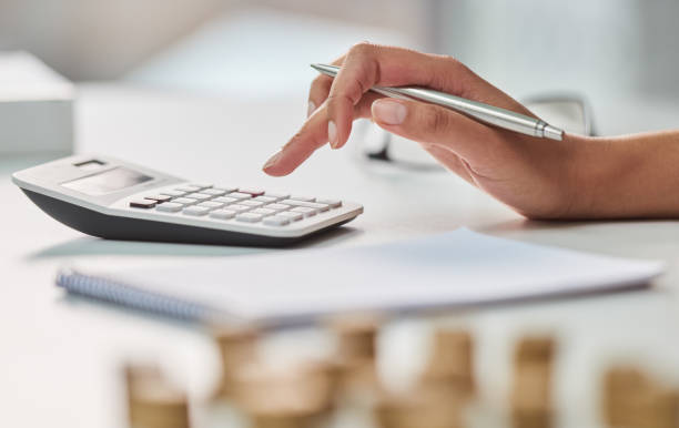 Making sure her rainy days are covered Cropped shot of an unrecognizable businesswoman working out her finances with a calculator and a notepad in her office money memo stock pictures, royalty-free photos & images