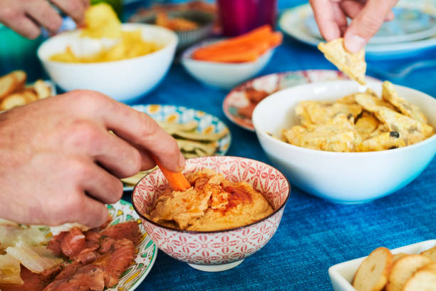 menschen mit einigen vorspeisen auf einem bunten tisch - delicatessen meat cold cuts chopped stock-fotos und bilder