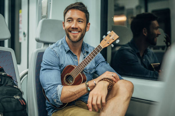 istock Handsome man playing with ukelele in subway train 1188386263