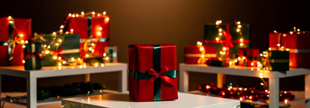 istock Christmas present on white table, defocused Christmas lights in background, bokeh 1188389131