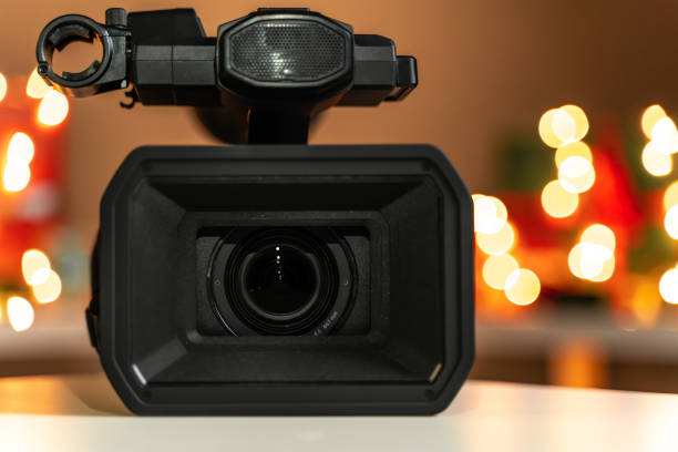istock Home video camera close-up, Christmas lights  and presents in background 1188389231