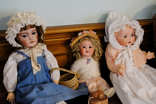 Close-up of three old-fashioned Victorian dolls.