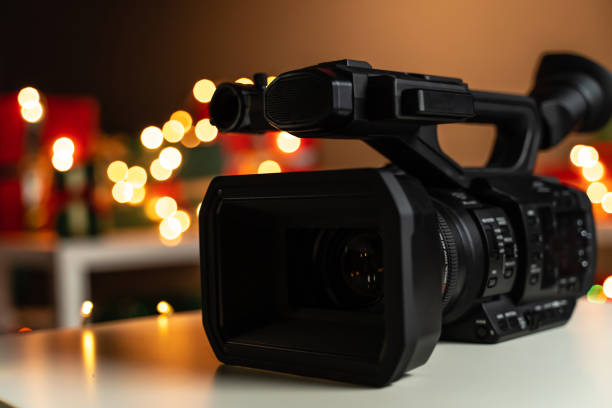 istock Home video camera in front Christmas lights  and presents in background 1188389497