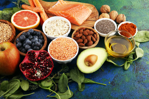 istock Healthy food clean eating selection: fish, fruit, vegetable, cereal, leaf vegetable on rustic background 1188390272