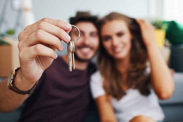 primer plano de pareja mostrando las llaves del nuevo apartamento - couple young women casual excitement fotografías e imágenes de stock