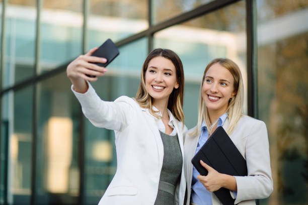 istock Two female colleagues taking a selfie on smart phone at work 1188393129