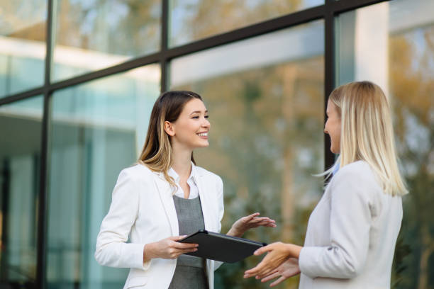 istock Two business women discussing work on tablet computer outdoors 1188393416