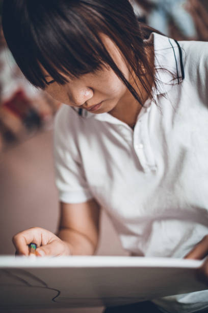 istock Young Asian woman drawing 1188393730