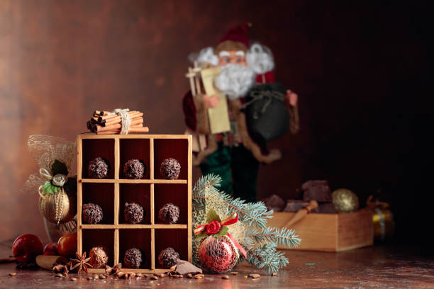 istock Chocolate candy in wooden box and Christmas decorations on a old brown table. 1188396382