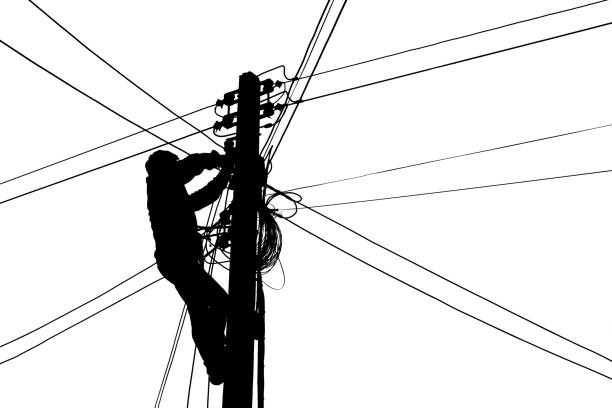Silhouette Electricians climb electric poles for connecting cables stock photo