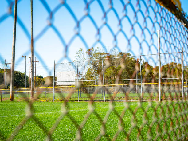 istock View of baseball out field through chain link fence 1188397328