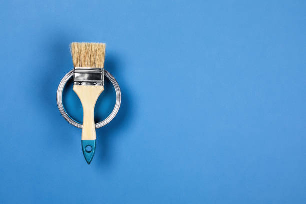 Blue background with paint jar and brush.