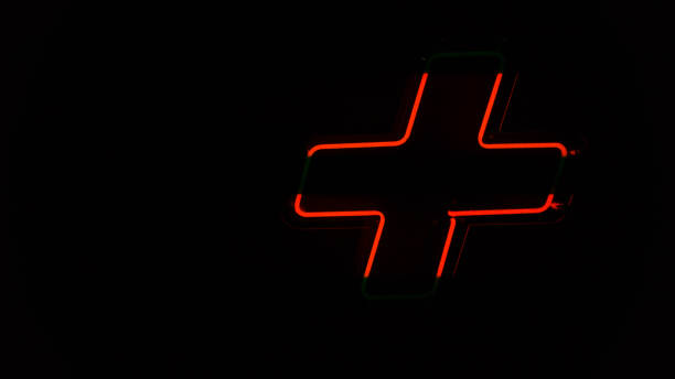 istock Illuminated red neon light, plus symbol on the wall 1188398345