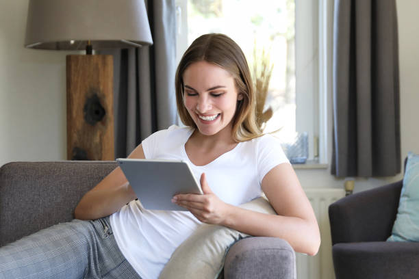 istock Young woman with white shirt on grey sofa 1188398436