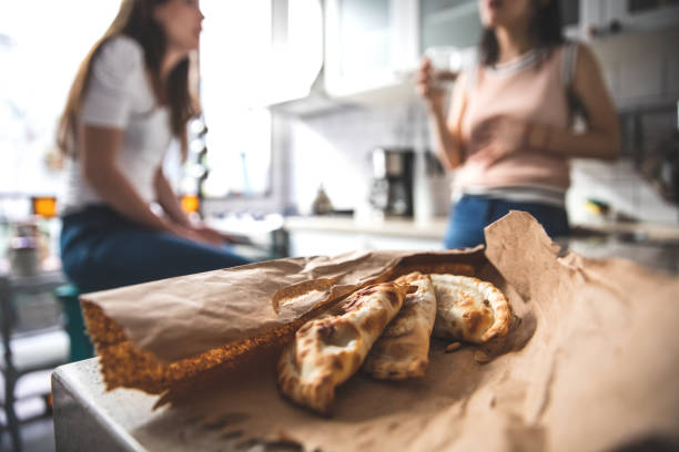 Woman eating empanada in her house in Buenos Aires
