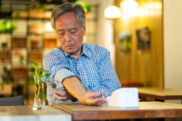 taiwanesisk senior man undersöker blodtryck - blodtryck orolig bildbanksfoton och bilder
