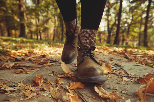 istock Women's legs standing in autumn leaves. 1188401764