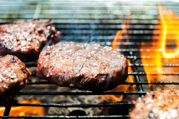 istock Burgers are cooking on grill with open flames 1188402797