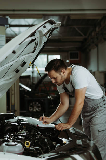 istock Young mechanic going through checklist in auto repair shop 1188406239