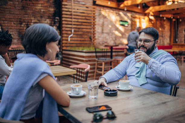 istock Man and woman sitting in sidewalk cafe 1188406403