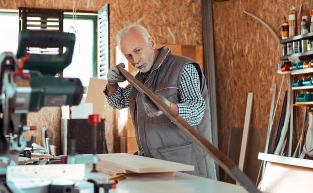 istock Carpenter checking curvature of a plank 1188406545