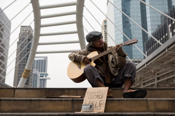 Old beggar play music for money