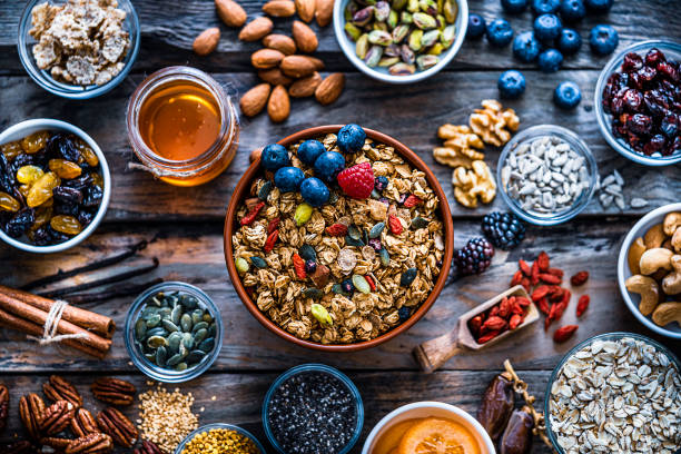 istock Healthy eating: granola bowl, seeds, nuts and fruits. Top view. 1188407938