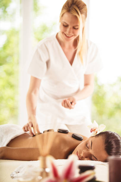 スパリゾートでホットストーンマッサージを受ける女性 - massage therapist stone spa treatment working ストックフォトと画像