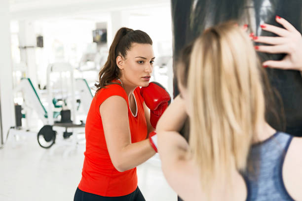 istock Female boxer in gym punching bag 1188410391