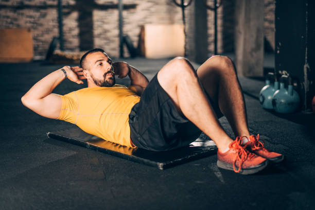 istock Strong athletic man doing a sit ups exercise in a gym 1188411309