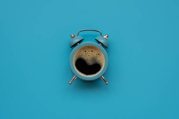 istock Alarm clock as coffee cup on blue background. Top view. Flat lay. Good morning concept 1188412356