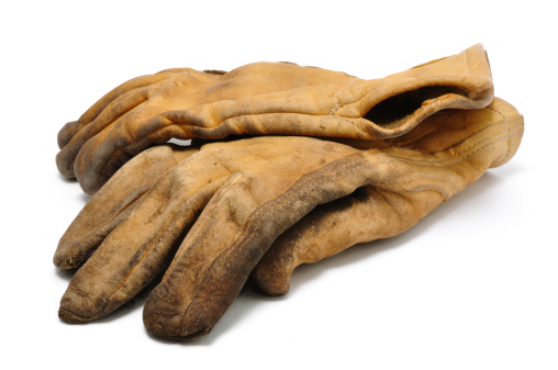 Old brown leather rigger work gloves on a white background