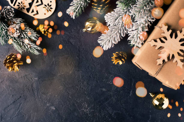 istock Christmas backdrop flat lay on dark background with gift, ball, fir and cone. 1188416078