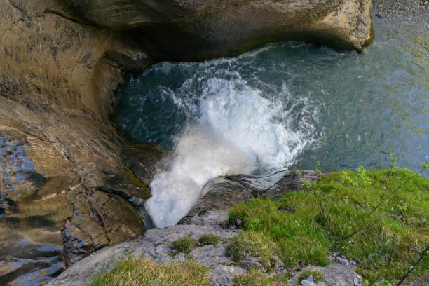 A dramatic close-up of a powerful waterfall cascading over rugged rocks, creating frothy white water and dynamic movement. The rushing water highlights the raw energy of nature, making it ideal for themes of adventure, environment, and natural forces.