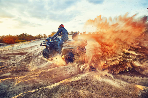 teen in sella atv in dune di sabbia facendo una svolta nella sabbia - motocross engine motorcycle extreme sports foto e immagini stock