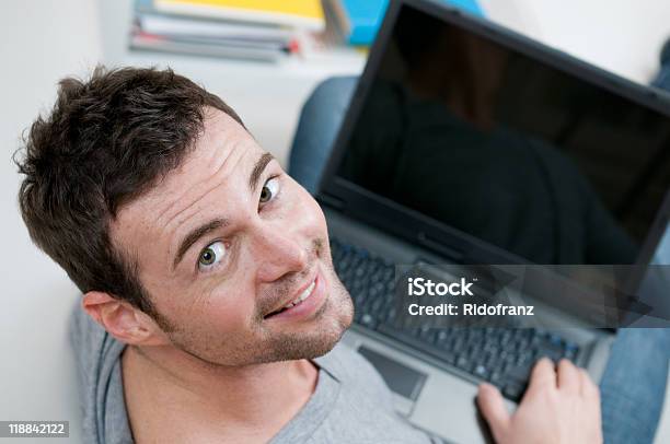 Sorridente Homem Casual Trabalhando No Computador Portátil - Fotografias de stock e mais imagens de 20-29 Anos