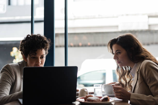 istock Two women with computer in meeting at a cafe 1188422400